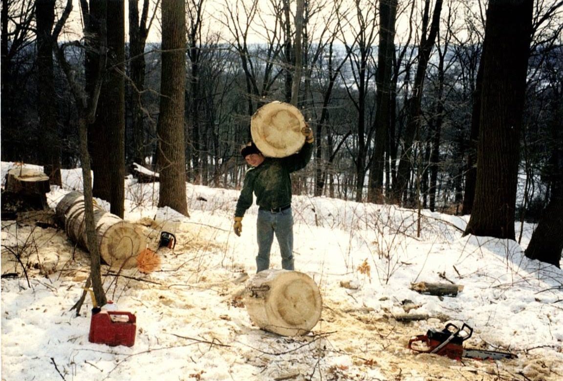 Tony holding a giant round of stump in the snow